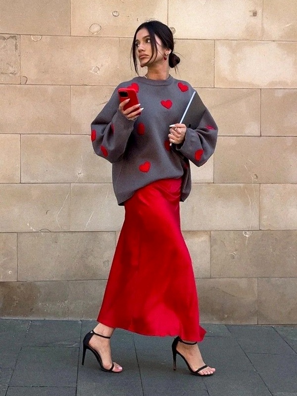 Casual yet chic grey heart-print sweater paired with flowing red satin skirt for Valentine's Day